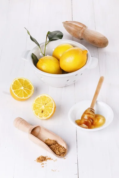 Organic lemons with honey and brown sugar over white background — Stock Photo, Image