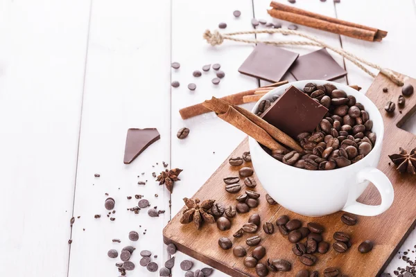 Coffee beans, spices and chocolate over white background — Stock Photo, Image