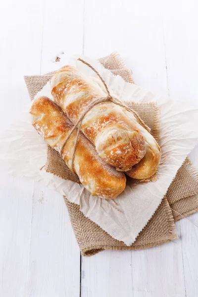 Frissen sült kenyér átfordul fehér fa háttér — Stock Fotó