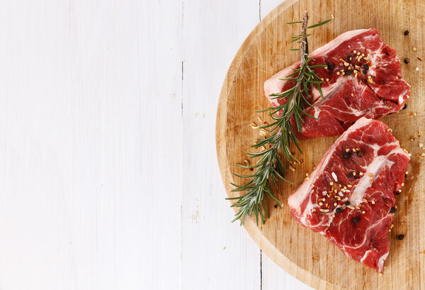 Red meat and rosemary over white background