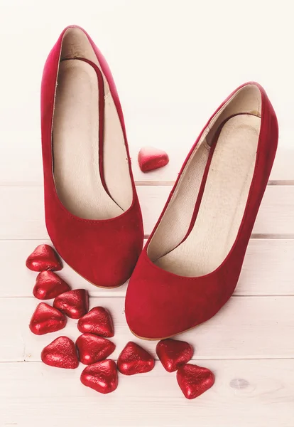 Sapatos vermelhos e corações de chocolate para Valentine — Fotografia de Stock