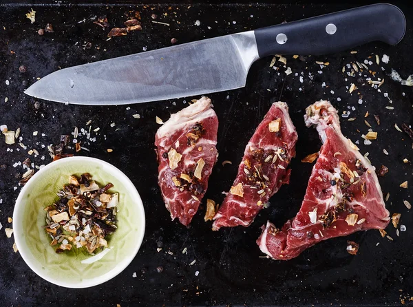 Rotes Fleisch und Gewürze vor rustikalem Metallhintergrund — Stockfoto