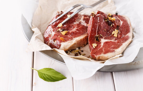 Red meat with fork over white background