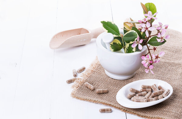 Herbal medicine capsules over white