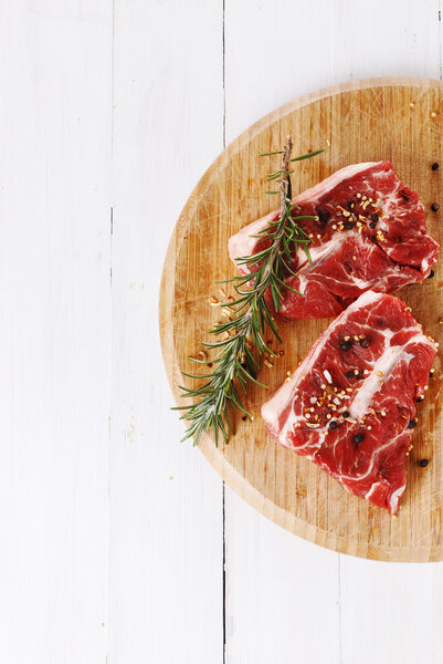 Red meat and rosemary over white background