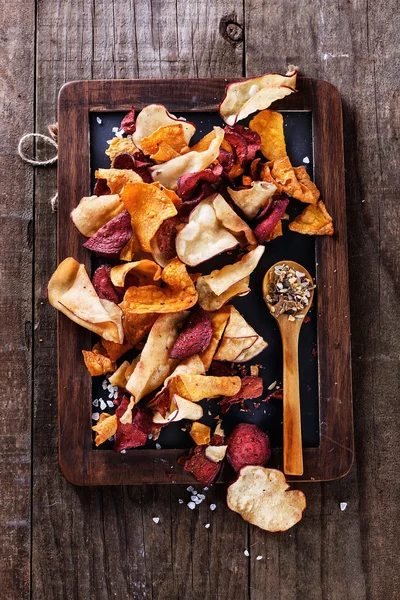 Healthy vegetable chips and seasoning on a rustic background — Stock Photo, Image