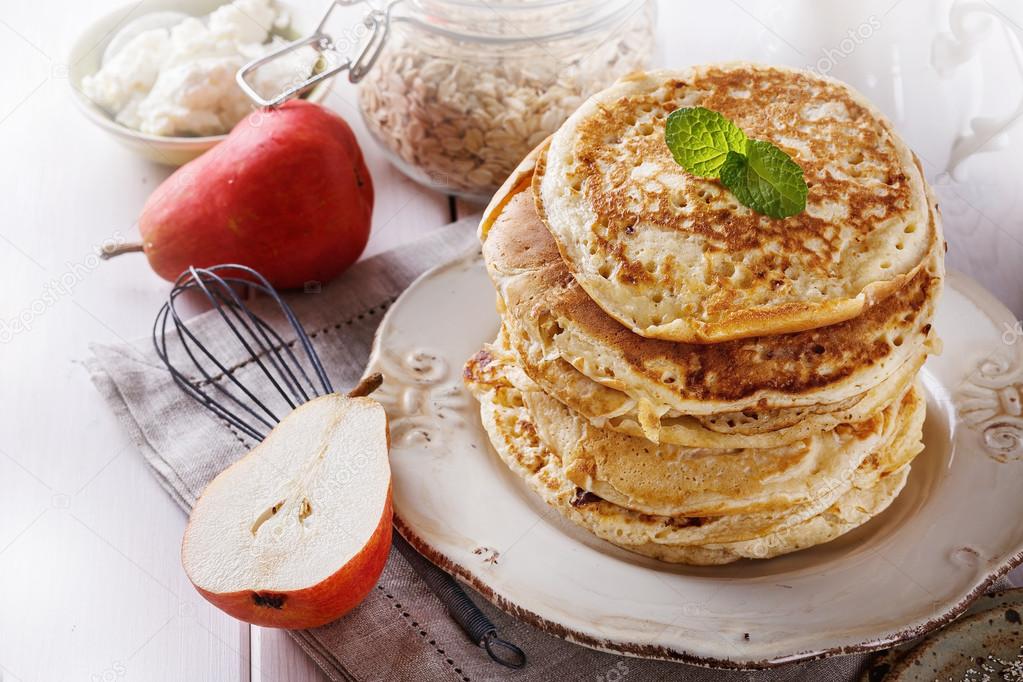 Healthy oat pancakes over white wooden background