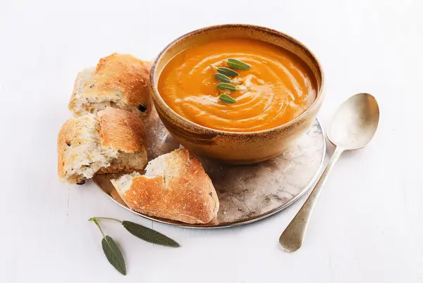 Soupe de citrouille avec pain rustique sur fond blanc — Photo