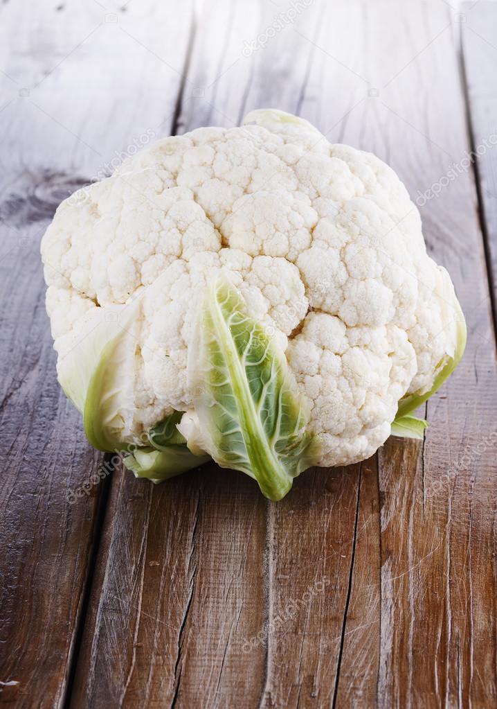 Single cauliflower head on a wooden background