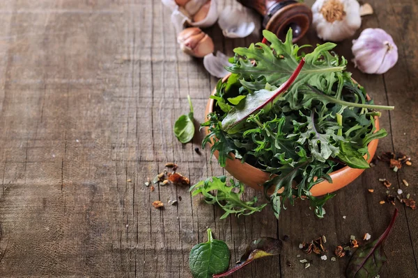 Leafy green mix over rustic wooden background — Stock Photo, Image