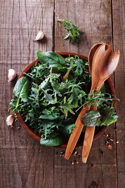 Leafy green mix over rustic wooden background — Stock Photo, Image