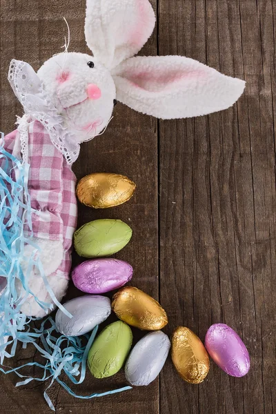 Paashaas en chocolade paaseieren op rustieke houten achtergrond — Stockfoto