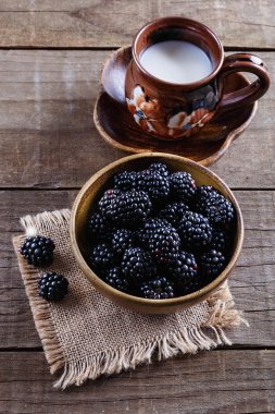 Ahşap rustik zemin üzerine kabın içinde olgunlaşmış taze böğürtlen