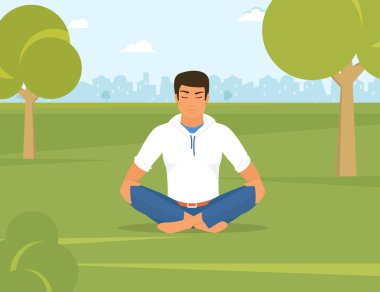 Adam lotus pozisyonu parkta oturuyor ve yoga yaparken