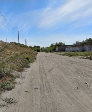Küçük tepenin yanında çimenlerle kaplı kuru, tozlu bir toprak. Kırsal yol dokusu arkaplanı.