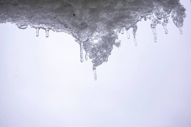 Buz sarkıtları. Sıcaktan eriyor. Baharın gelişi. Bahar damlası. Buz erir..