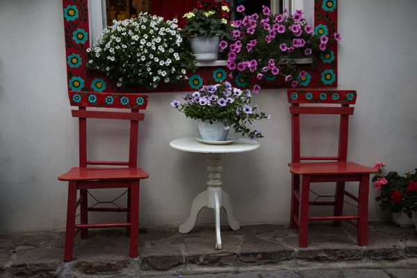 Sillas rojas en las flores — Foto de Stock