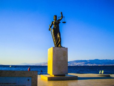 Adalet heykeli kılıç dengesi pirinç heykel deniz kıyısı mavi gökyüzü