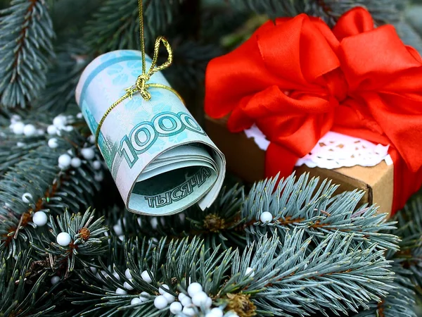 The Christmas tree is decorated with money and gifts. Banknote Russian one 1000 thousand rubles.