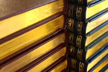 Sayfaların altın kenarlı kitap yığını.