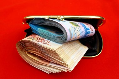 Kırmızı açık bir cüzdanda Rus rublesi banknotları. Banknotların değeri iki bin beş bin ruble..