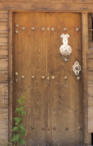 Ancient door in the village of Kemal. Symbolic handles on the doors. — Stock Photo, Image