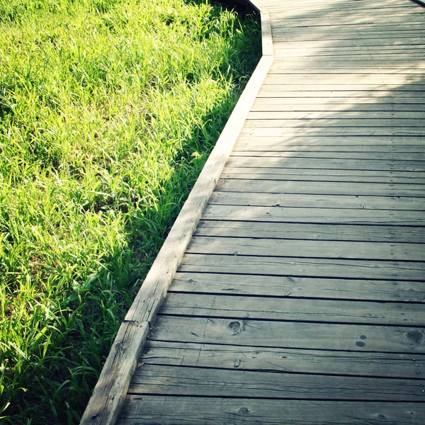 Ξύλινο μονοπάτι σε ένα πάρκο άνοιξη. Παλιάς φωτογραφίας. — Φωτογραφία Αρχείου