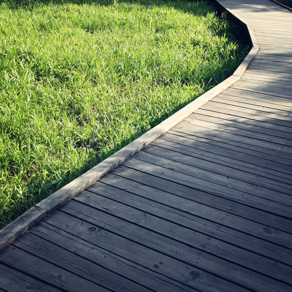 Wooden path in a spring park. Aged photo.