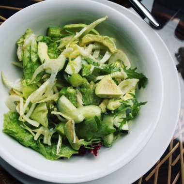 Beyaz yuvarlak plaka üzerinde basit yeşil salata. Vegan