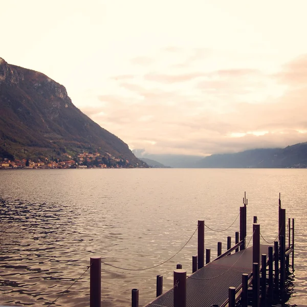 Muelle pequeño y aguas tranquilas. Día nublado en el lago Como —  Fotos de Stock