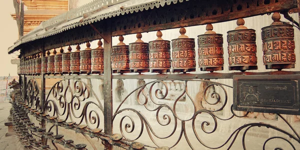 Tibetské modlitební mlýnky s mantrami poblíž Swayambhunath Stupa - vinobraní Foto. — Stock fotografie