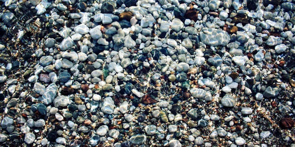 Piedras lisas bajo el agua. Efecto tonificado . — Foto de Stock