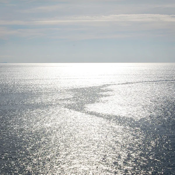 Mar tranquilo y un sendero en barco. Luz solar en el agua . — Foto de Stock