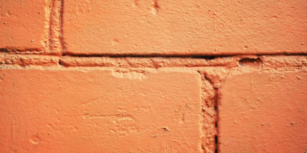 Τοίχο από τούβλα ζωγραφισμένα πορτοκαλί. Κινηματογράφηση σε πρώτο πλάνο για το σκηνικό. — Φωτογραφία Αρχείου