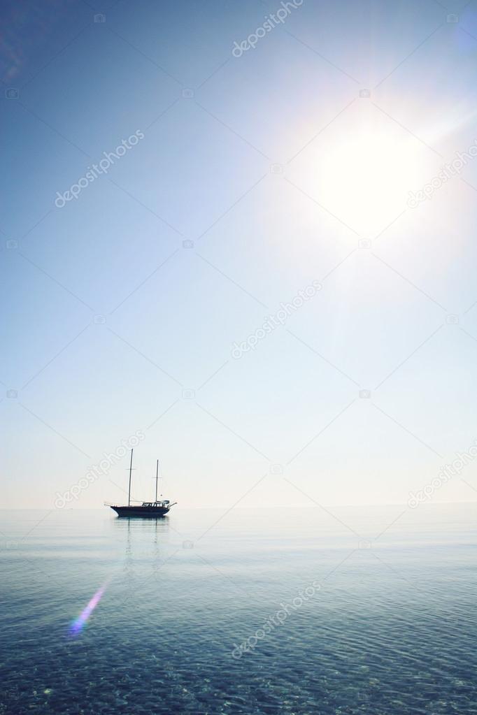 Morning sea with boat on the horizon. Aged photo.