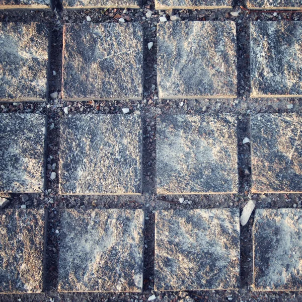 Typical pavement. Stone roadway. Square pattern. — Stock Photo, Image