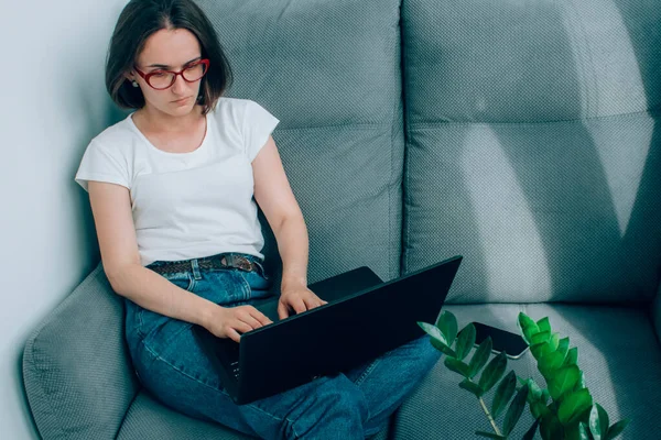 Beautiful young business woman or freelancer, working remotely from home using laptop. Shopping online using search engines. Online education, WFH and safe online shopping concept, selective focus