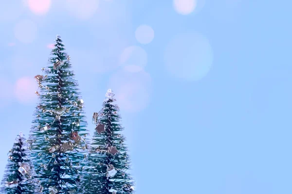 Fundo de Natal na moda - Árvore de Natal ou árvore de Ano Novo com decorações e luzes bokeh no fundo azul da moda com copyspace para o seu texto. Foco seletivo, lugar para texto — Fotografia de Stock