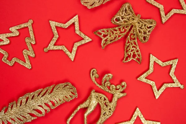 Enfeites de Natal e Ano Novo - decorações douradas em fundo vermelho com copyspace para o seu texto. Foco seletivo — Fotografia de Stock