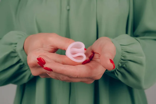 Kadın elinin mükemmel manikürlü, elinde pembe menstrüel bardakla nasıl kullanılacağını gösteren bir fotoğraf. Kadın sağlığı ve hijyen kavramı, alternatif hijyen ürünleri — Stok fotoğraf