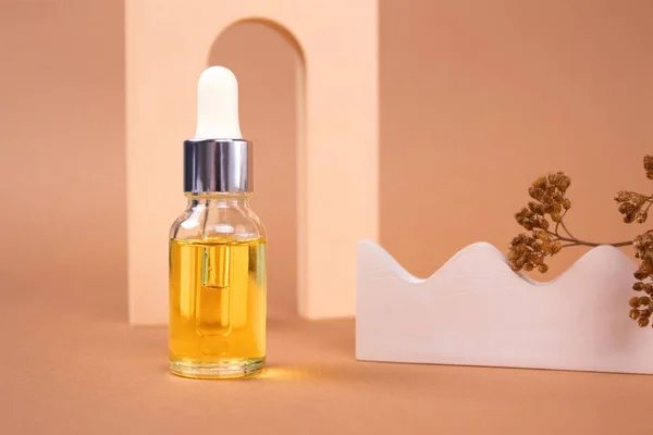 Doğal organik kozmetik ürünleri şişesi - hyaluronik asit, serum, nemlendirici ya da yaşlanma önleyici yüz yağı. Biege 'deki temel yağ hala yaşam bileşimi. Aromaterapi konsepti. Model