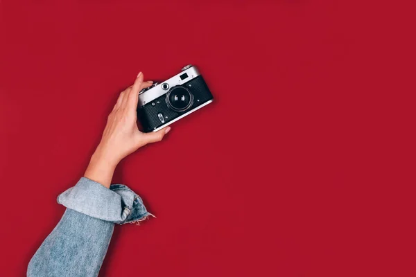 女性手拿着红色背景的老式复古摄影相机 并有文字复制空间 时尚老式摄影 在线摄影学校概念 选择性焦点 — 图库照片