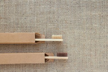 Kağıt ambalaj kutularındaki doğal bambu diş fırçalarının fotokopi alanındaki kırsal arkaplan resimleri. Sürdürülebilir yaşam tarzı, sıfır atık evde banyo gereksinimleri. Seçici odak