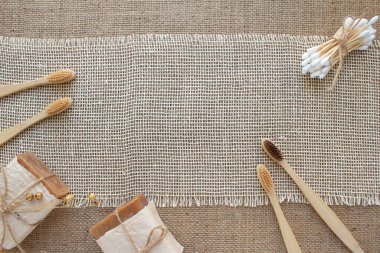 Doğal banyo ve spa aletleri çerçevesi, sürdürülebilir sıfır atık ve yaşam tarzı konsepti. Ahşap diş fırçaları, bambu çubukları, sabun, arkaplanda kopya alanı olan diş tozu.