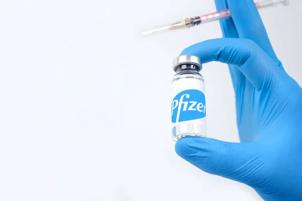 Lviv, Ucrania - 28 de diciembre de 2020: Médico o científico que sostiene la vacuna Pfizer Biontech, fondo blanco con espacio para copias - coronavirus de prevención COVID-19, concepto de vacunación global. Enfoque selectivo — Foto de Stock