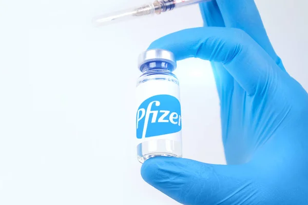 Lviv, Ucrania - 28 de diciembre de 2020: Médico o científico que sostiene la vacuna Pfizer Biontech, fondo blanco con espacio para copias - coronavirus de prevención COVID-19, concepto de vacunación global. Enfoque selectivo — Foto de Stock