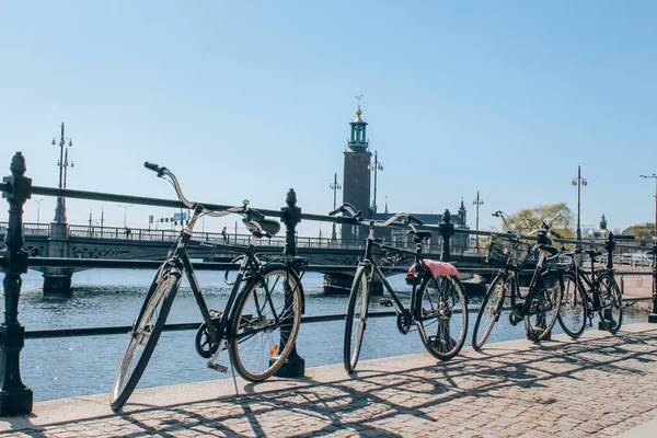 Stockholm, Svédország - 2019. május 1.: Szcenírozott napos napos panoráma a városi rakparton kerékpárral és a városházán, az Óváros Stockholmban. Városnézés koncepció és tavaszi vakáció Svédországban. Szelektív fókusz — Stock Fotó