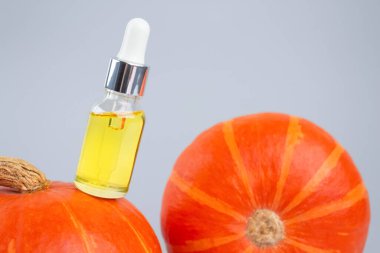 Modern organik kozmetik ürünü damlatan şişenin görüntüsü. Cilt bakımı için doğal kabak çekirdeği yağı ya da kabaklı saç. Güzellik ürünleri ve spa konsepti, seçici odaklanma