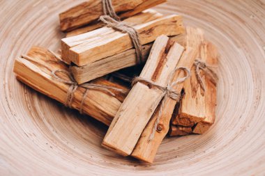 Palo Santo ağacı, Latin Amerika 'nın kutsal tütsü ağacı olan ahşap kaseye yapışır. Meditasyon, akıl sağlığı ve kişisel tatmin kavramı. Seçici odak