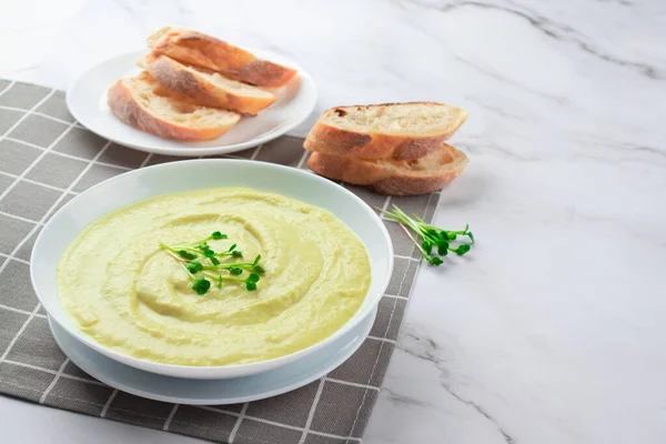 Klasik fransız dondurulmuş krema çorbası vichyssoise - sıcak ya da soğuk patates püresi çorbası üzerine mikroyeşiller ve mermer masa arkaplanı ve ekmek. Sağlıklı gıda konsepti. Seçici odak